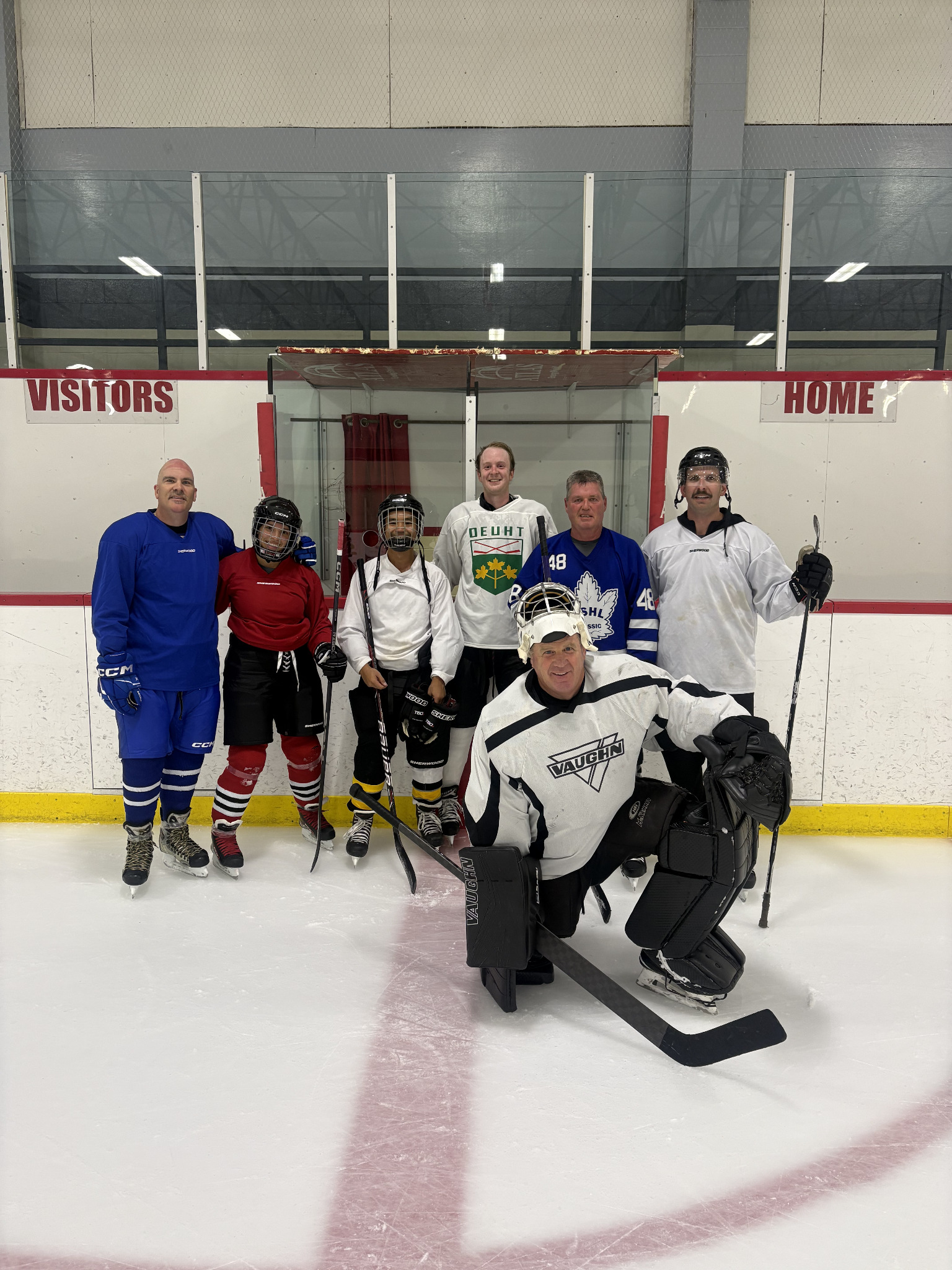 Never 2 Late Hockey participants and goalie at the rink